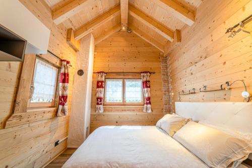 a bedroom in a log cabin with a bed in it at Blizzard apartments Kevin in Arabba