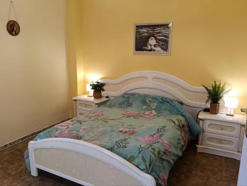 a bedroom with a bed with a floral bedspread and two night stands at Kitsch apartment in Rasquera