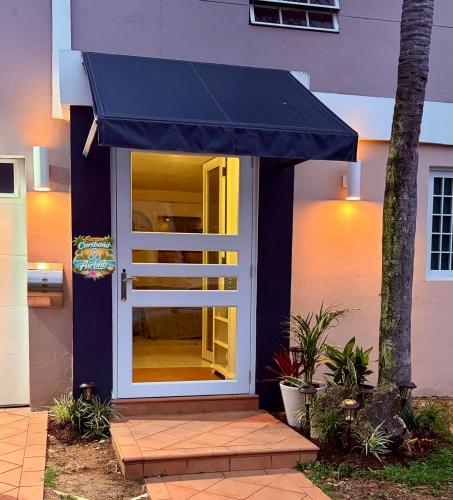 a blue awning on a house with a porch at Escape Caribeño in Levittown