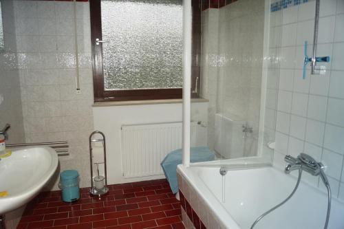 a bathroom with a tub and a sink and a toilet at Ferienwohnung Notos- Eislingen in Eislingen
