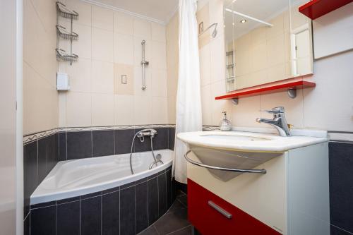 a bathroom with a sink and a bath tub at Charming Maisonette In Southern Suburbs in Athens