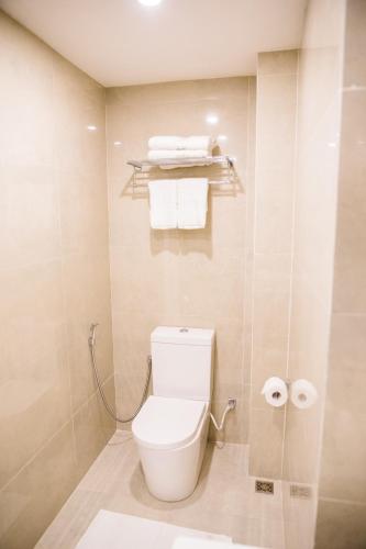 a bathroom with a toilet and towels in it at Venue Colombo in Colombo
