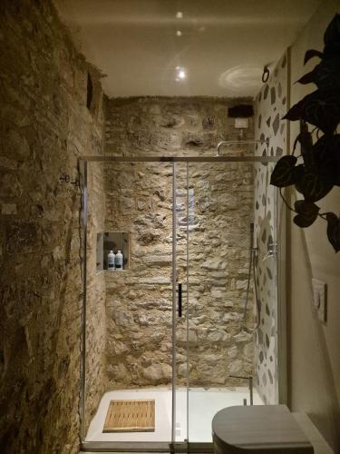 a bathroom with a shower with a stone wall at Loft in Love in Spello