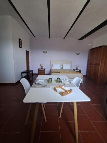a living room with a white table and a bed at Monte das Galhanas in Monte do Pigeiro