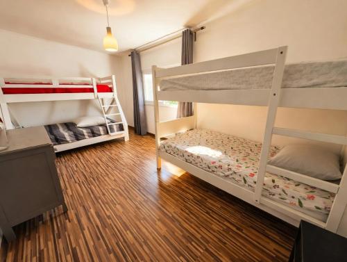 two bunk beds in a room with wooden floors at Akistay Guest House - Caparica in Costa da Caparica