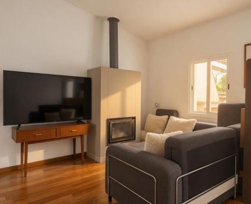 a living room with a couch and a flat screen tv at Akistay Guest House - Caparica in Costa da Caparica
