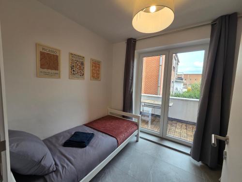 a bedroom with a bed and a large window at Flexi flat Gosselies Providence 12 in Charleroi