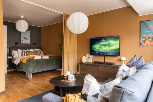 a living room with a couch and a bed and a television at Guestly Homes - Central Premium Studio in Västerås