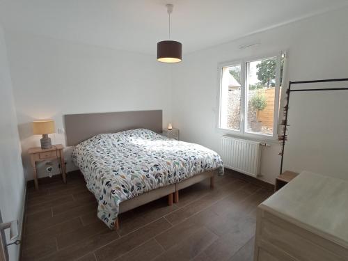a bedroom with a bed and a window at Gîte du Bois de Drancourt in Drancourt