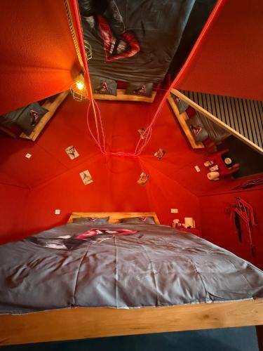 a red room with a bed in a room with shelves at Intimissima apartman in Odorheiu Secuiesc