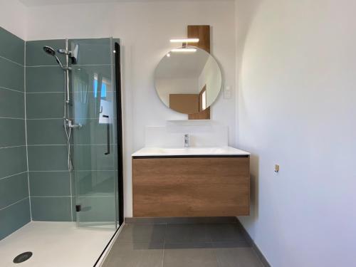 a bathroom with a sink and a shower with a mirror at Gîte du Bois de Drancourt in Drancourt