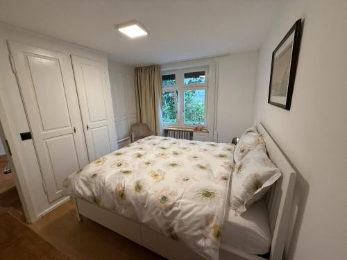 a small bedroom with a bed and a window at Haus Enisa in Horgen