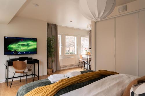 a bedroom with a large bed and a flat screen tv at Guestly Homes - Central Smart Studio in Västerås