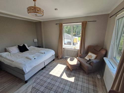 a bedroom with a bed and a chair and a window at Ankis i Virserum in Virserum