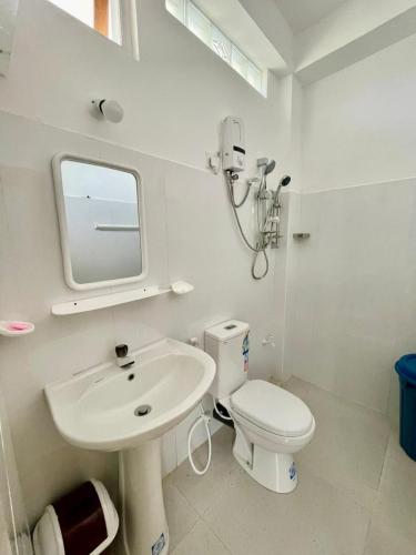 a white bathroom with a sink and a toilet at Elegant Mist Villa in Nuwara Eliya