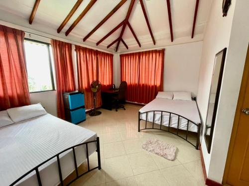a bedroom with two beds and a desk in it at Elegant Mist Villa in Nuwara Eliya