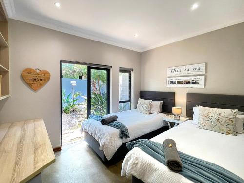 two beds in a room with a heart on the wall at Elements Private Golf Reserve 109 in Moheme