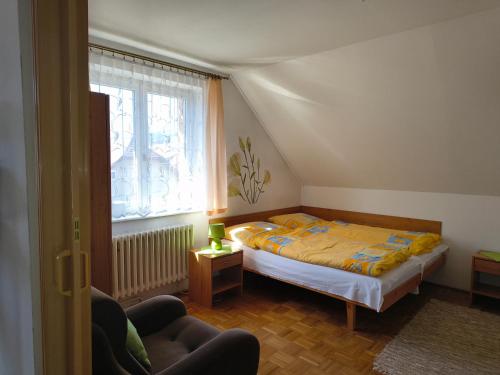 a small bedroom with a bed and a window at Privat Ľubka in Zuberec