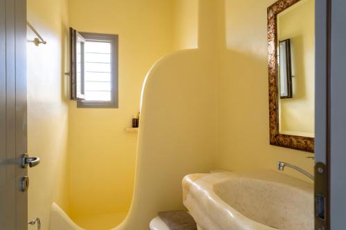 a bathroom with a tub and a mirror at Infinity Blue - Villa A in Aspro Chorio Paros