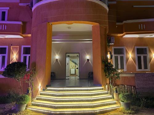a building with stairs leading to a door with lights at Tutankhamun Pyramids boutique in Cairo