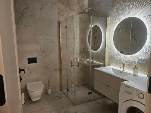 a bathroom with a shower and a sink and a toilet at Cisza nad Kalwą in Pasym