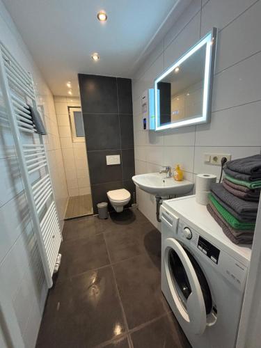 ein Badezimmer mit Waschmaschine und Waschbecken in der Unterkunft Altes Bierhaus Hotel Zimmervermietung in Arzbach