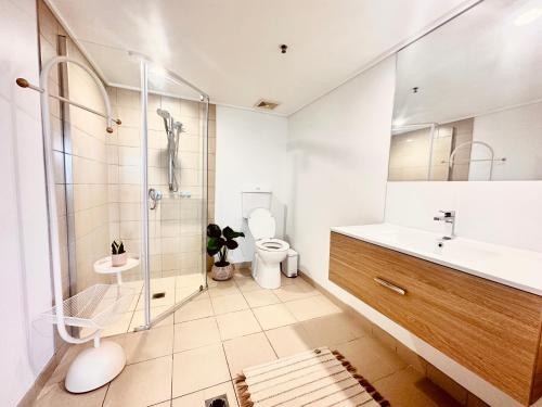 a bathroom with a shower and a toilet and a sink at Prime CBD High Rise Apartment in Cairns