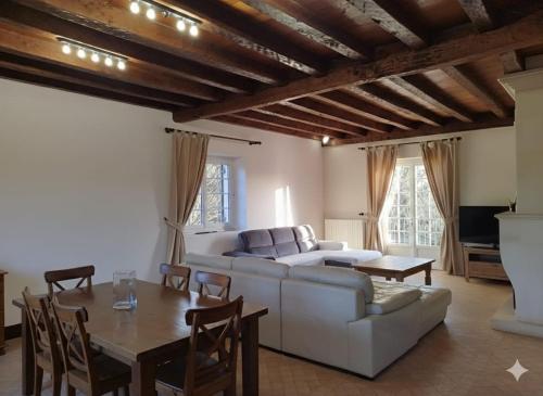 a living room with a white couch and a table at Le Clos Périgourdin in Église-Neuve-de-Vergt