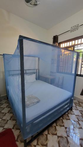 a bedroom with a blue canopy bed in a room at Mamayi Homestay in Mto wa Mbu