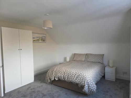 a bedroom with a bed and a white cabinet at Teach Na Dálaigh in Annagry