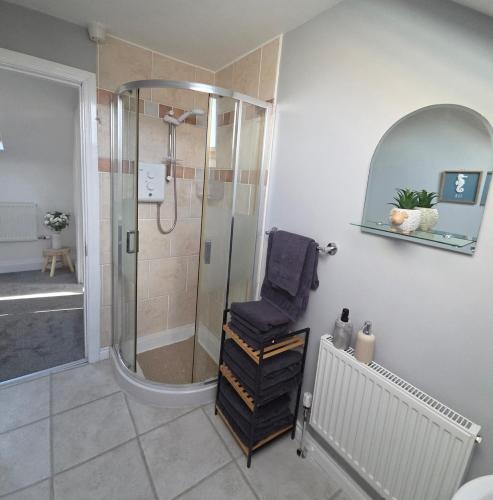 a bathroom with a shower and a chair in it at Teach Na Dálaigh in Annagry