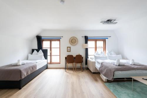 a white bedroom with two beds and a table at Spacious 80 m2 Apartment I 3 Rooms I Up to 8 Guests I Near Train Station in Steyr