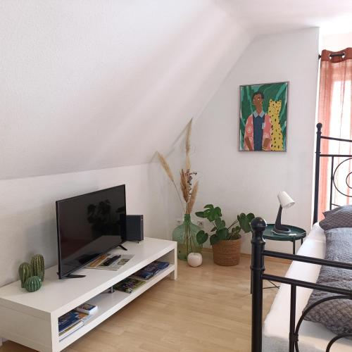 a living room with a tv on a white cabinet at Urban Apple in Bad Mergentheim