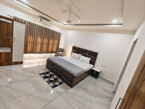a bedroom with a bed and a chair in it at Rudra BNBF in Gandhidham