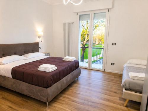 a bedroom with a large bed and a sliding glass door at Central Chic Apartment in Imola