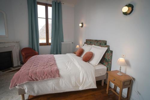a bedroom with a white bed and a window at La Leugnyçoise in Leugny