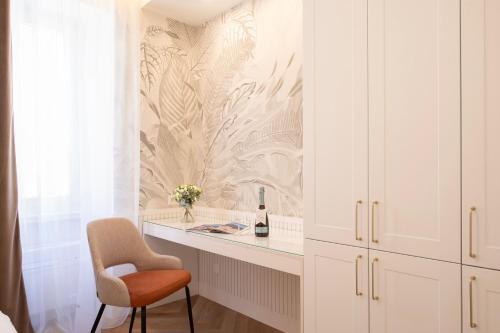 a room with a desk with a chair and a bottle of wine at Central Suites in Lugano