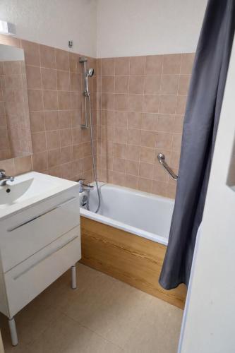 a bathroom with a tub and a sink and a shower at Vue montagne exceptionnelle T2 Cosy avec Balcon proche du lac in Embrun