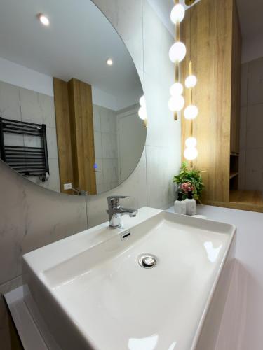 a bathroom with a white sink and a mirror at The Calaya - Aparthotel Saranda in Sarandë