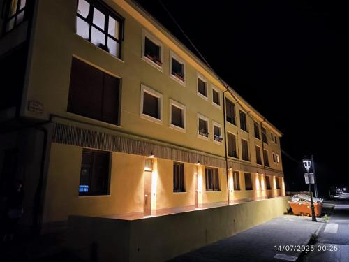 a building with lights on the side of it at night at Apartamento La Mandrágora in Arenas de Cabrales