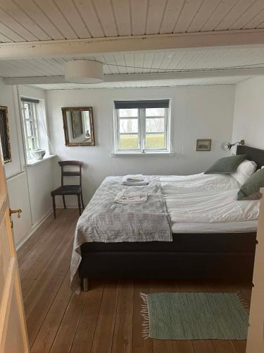 ein Schlafzimmer mit einem großen Bett und einem Stuhl in der Unterkunft Tøndegården 3 rooms apartment in Odense