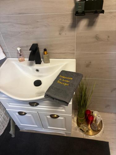 a bathroom with a sink with a book on it at LAKEVIEW A-frame ESCAPE in Tisa
