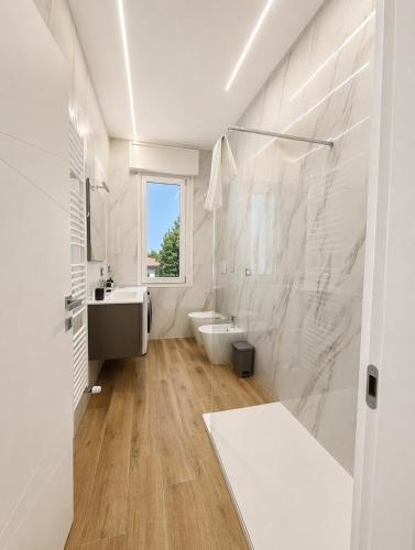 a white bathroom with a sink and a toilet at Central Chic Apartment in Imola