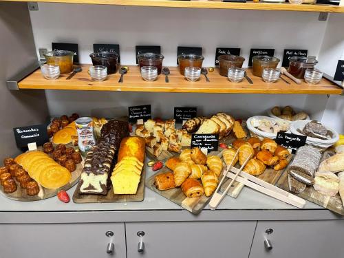 a bunch of different types of bread and pastries on shelves at Hôtel Lapeyronie in Montpellier