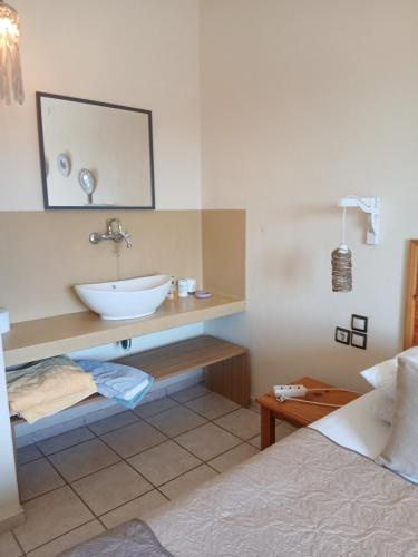 a bathroom with a sink and a mirror and a bed at Villa Krini in Skiathos