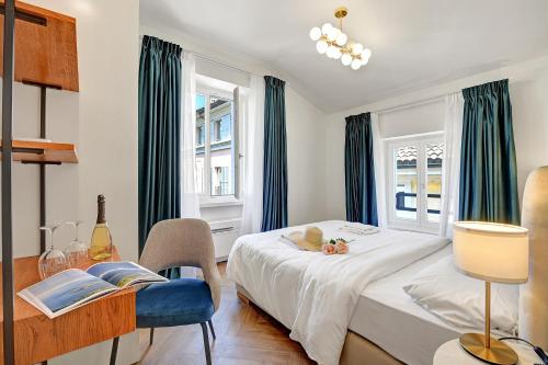 a bedroom with a bed and a desk and a window at Central Suites in Lugano