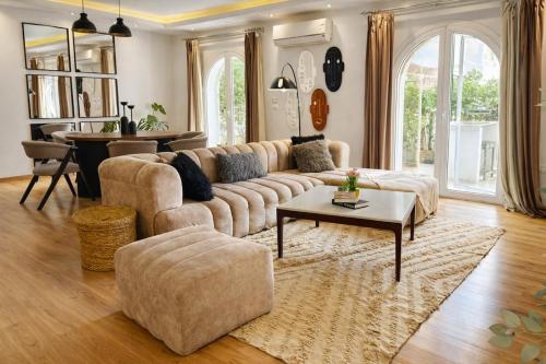 a living room with a couch and a table at Elegant Hydepark Apt With Garden in New cairo