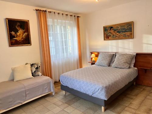 a bedroom with a bed and a window at Le Petit Clos périgourdin in Église-Neuve-de-Vergt