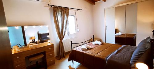 a bedroom with a bed and a dresser and a mirror at Hercules casa in Kymi