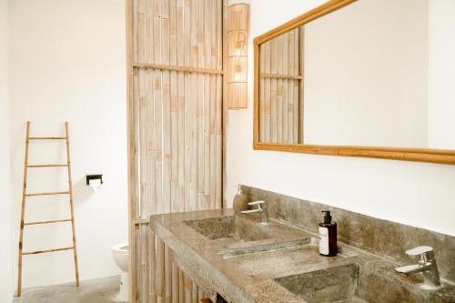 a bathroom with a sink and a mirror at Casa Solisa in Kerobokan